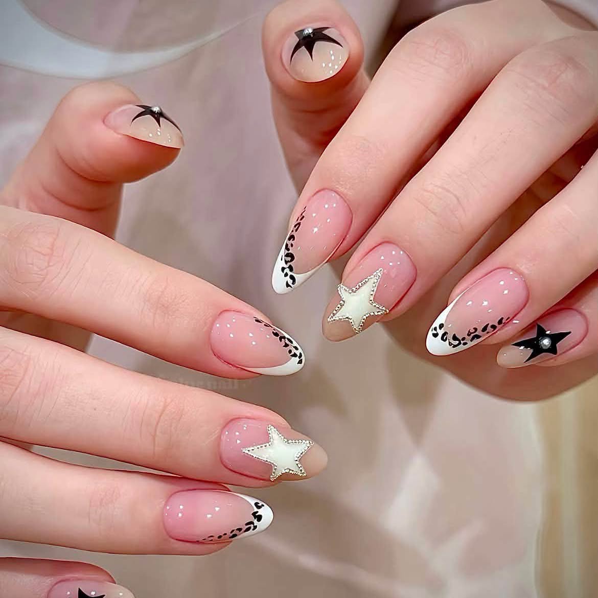 Short nude nails with black stars and white French tips